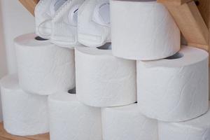 Stocks of toilet paper rolls on shelf photo