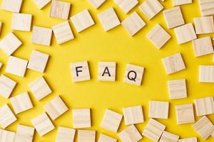 Wooden blocks with abbreviation FAQ on the yellow background photo