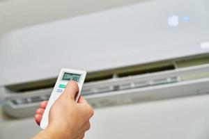 Hand adjusting temperature on air conditioner photo