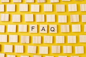 Wooden blocks with abbreviation FAQ on the yellow background photo