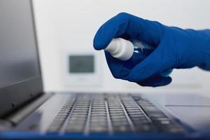 Hand cleans with an antibacterial antiseptic sanitizer spray laptop photo