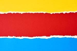 Torn ripped paper edge with a copy space, red, blue and yellow color background photo