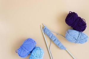 op view of gray knitting wool and knitting needles on pastel orange background. photo