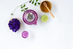 Top view of Butterfly pea flower tea with lemons on white background. Health drink concept. photo