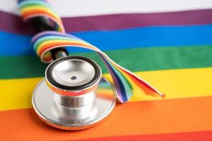 stethoscope on rainbow flag background, symbol of LGBT pride month  celebrate annual in June social, symbol of gay, lesbian, bisexual, transgender, human rights and peace. photo