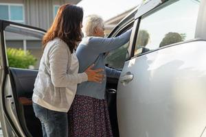 Asian senior or elderly old lady woman patient sitting on wheelchair prepare get to her car, healthy strong medical concept. photo