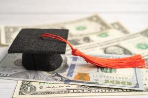 Graduation gap hat on US dollar banknotes money, Education study fee learning teach concept. photo
