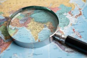 Bangkok, Thailand - May 01, 2022 India, Magnifying glass close up with colorful world map. photo