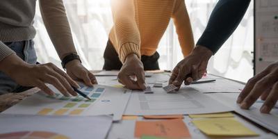 Close up ux developer and ui designer brainstorming about mobile app interface wireframe design on table with customer breif and color code at modern office.Creative digital development agency photo