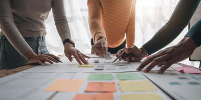 Close up ux developer and ui designer brainstorming about mobile app interface wireframe design on table with customer breif and color code at modern office.Creative digital development agency photo