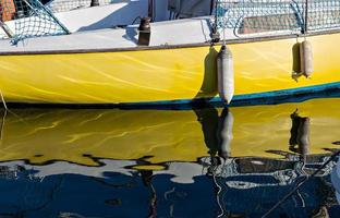 Pleasure boat with reflections in the water in the marina. Horizontal image. photo