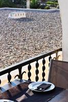 Restaurant table with plate and cutlery in front of a terrace. Holidays. Relax. photo