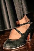 zapato negro cerca de una bailaora de flamenco. baile tipico español. imagen vertical