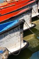 Boats waiting in the pond tied with a chain. Vertical image. photo