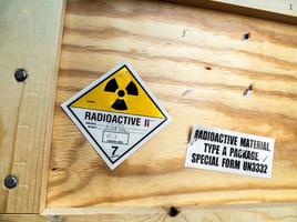 etiqueta de advertencia de material radiactivo al lado del paquete de madera de transporte foto