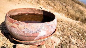 water in a clay pot for birds to drink in summer weather photo