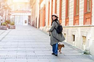 young attractive woman playing with her dog on the city street, lifestyle people concept. Beauty woman with her dog playing outdoors photo