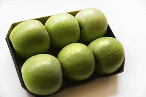 Six green apples on a cardboard backing on a white background. Delicious green apples close-up. photo