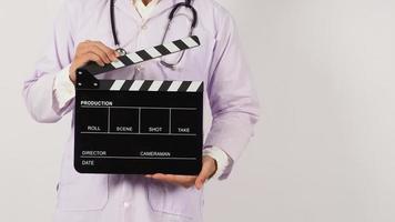 Doctor's holding Black Clapper board in hand on white background. Studio shooting. photo