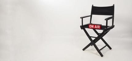 Black director chair and on air box on the chair on white background. studio shot photo