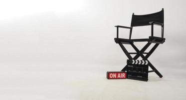 Black director chair and black clapper board and on air box on white background photo