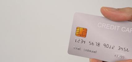 la mano es una tarjeta de crédito plateada sobre fondo blanco. foto