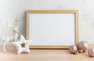 maqueta de marco de madera en blanco blanco con adornos navideños foto