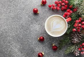 taza de café con leche y decoración navideña en un fondo de hormigón oscuro foto