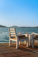 An armchair in a cafe against the background of the sea, evening time, sit in a cafe to admire the sunset. Background idea for holiday advertising. Weekend at sea photo