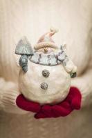 Woman Wearing Seasonal Red Mittens Holding Glass Snowman photo