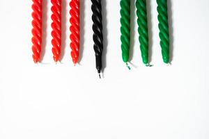 Happy Kwanzaa concept. Afro-American holiday. Seven candles - red, black and green. African heritage symbol on white background. photo