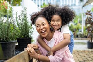 Portrait of African kid is hugging each other at the local garden center nursery beside the herb and summer plant for weekend gardening and outdoor concept photo