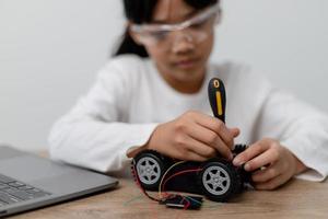 Asia students learn at home in coding robot cars and electronic board cables in STEM, STEAM, mathematics engineering science technology computer code in robotics for kids concept. photo