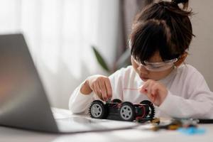 Asia students learn at home in coding robot cars and electronic board cables in STEM, STEAM, mathematics engineering science technology computer code in robotics for kids concept. photo