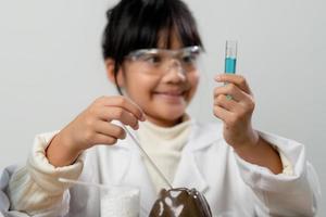 education, science, chemistry and children concept - kids or students with test tube making experiment at school laboratory photo