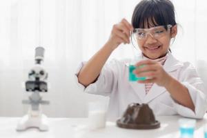 education, science, chemistry and children concept - kids or students with test tube making experiment at school laboratory photo