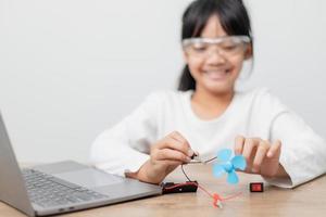 Asia students learn at home in coding robot cars and electronic board cables in STEM, STEAM, mathematics engineering science technology computer code in robotics for kids concept. photo