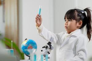 concepto de educación, ciencia, química y niños - niños o estudiantes con tubos de ensayo haciendo experimentos en el laboratorio escolar foto