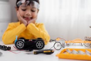 Asia students learn at home in coding robot cars and electronic board cables in STEM, STEAM, mathematics engineering science technology computer code in robotics for kids concept. photo