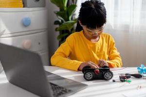 Asia students learn at home in coding robot cars and electronic board cables in STEM, STEAM, mathematics engineering science technology computer code in robotics for kids concept. photo