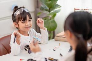 Asia students learn at home in coding robot cars and electronic board cables in STEM, STEAM, mathematics engineering science technology computer code in robotics for kids concept. photo
