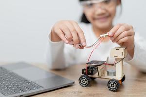 Asia students learn at home in coding robot cars and electronic board cables in STEM, STEAM, mathematics engineering science technology computer code in robotics for kids concept. photo