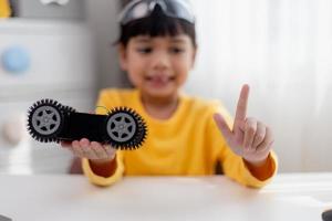 Asia students learn at home in coding robot cars and electronic board cables in STEM, STEAM, mathematics engineering science technology computer code in robotics for kids concept. photo