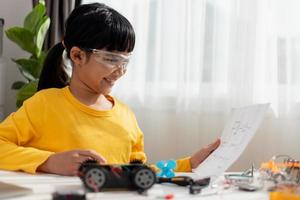 Asia students learn at home in coding robot cars and electronic board cables in STEM, STEAM, mathematics engineering science technology computer code in robotics for kids concept. photo