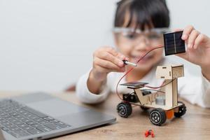 Asia students learn at home in coding robot cars and electronic board cables in STEM, STEAM, mathematics engineering science technology computer code in robotics for kids concept. photo