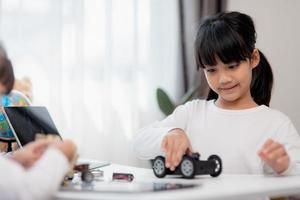 Asia students learn at home in coding robot cars and electronic board cables in STEM, STEAM, mathematics engineering science technology computer code in robotics for kids concept. photo