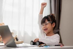 Asia students learn at home in coding robot cars and electronic board cables in STEM, STEAM, mathematics engineering science technology computer code in robotics for kids concept. photo
