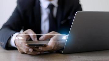 People hand using laptop or computor searching for information in internet online society web with search box icon and copyspace. photo