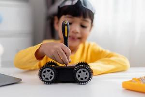 Asia students learn at home in coding robot cars and electronic board cables in STEM, STEAM, mathematics engineering science technology computer code in robotics for kids concept. photo