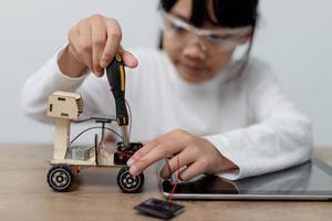 Asia students learn at home in coding robot cars and electronic board cables in STEM, STEAM, mathematics engineering science technology computer code in robotics for kids concept. photo